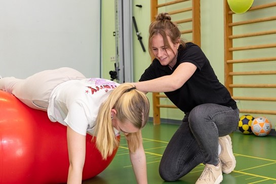 Fysiotherapeut Helpt Patiënt Met Oefening Op Een Bal